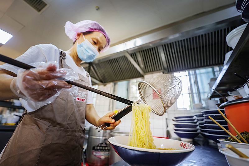 店员正制作烫面小吃。冯树风摄
